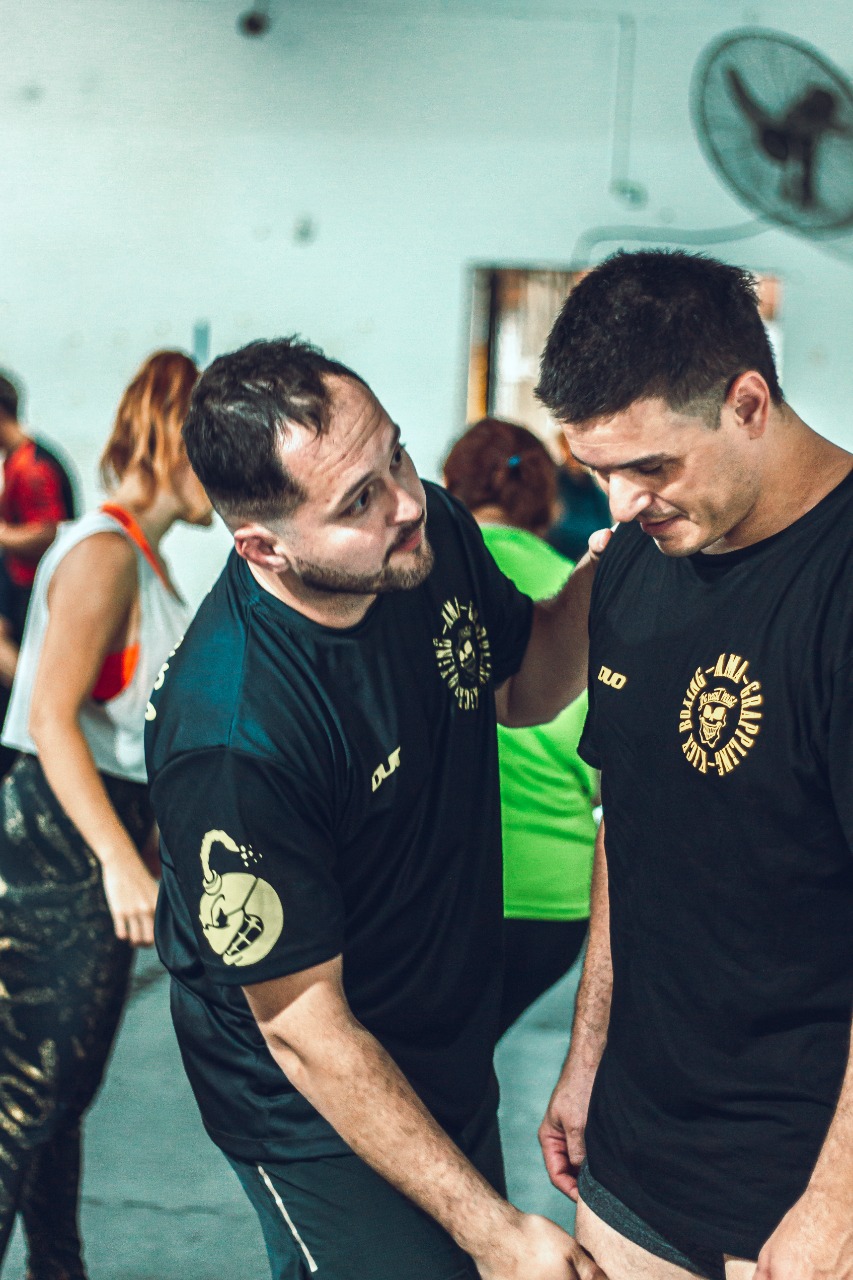 el profesor de gimnasio explicando el ejercicio a un alumno