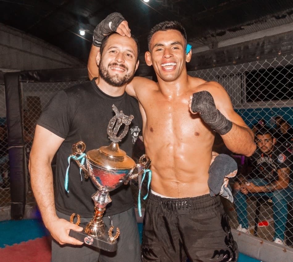 el profe sosteniendo el trofeo al lado de Chavy